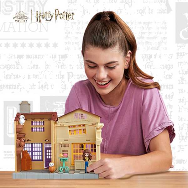 A teenage girl playing with Wizarding World Harry Potter toys.